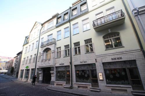 a building on a street with a person walking past it at Tallinn City Apartments Old Town Suites in Tallinn