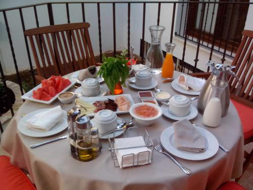 une table avec un tissu de table blanc et de la nourriture dans l'établissement La Posada de Quijada, à Grenade