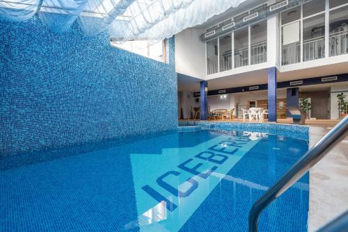 uma piscina com azulejos azuis ao lado de um edifício em Hotel Iceberg Bansko em Bansko