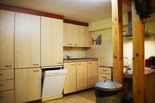 eine Küche mit Holzschränken und einem weißen Kühlschrank in der Unterkunft Cozy room in Kaunas in Kaunas