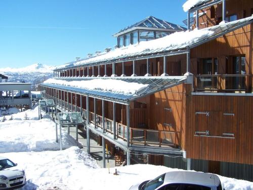 a building covered in snow with cars parked in front of it at Il Fraitevino hotel bed & breakfast in Sestriere