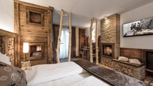 um quarto com uma cama e uma lareira em Sporthotel Romantic Plaza em Madonna di Campiglio