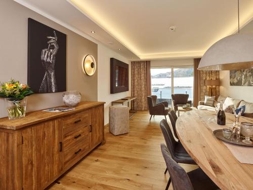 uma sala de jantar e sala de estar com mesa e cadeiras em A-VITA Viktoria & A-VITA living luxury apartments em Seefeld in Tirol