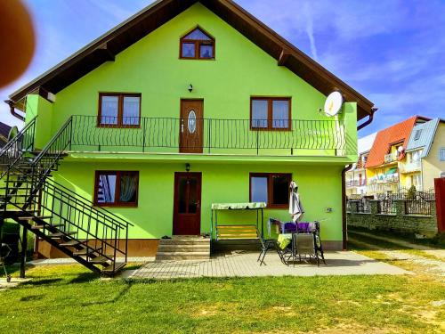 ein grünes Haus mit einer Treppe davor in der Unterkunft Homestay Renata in Nová Lesná