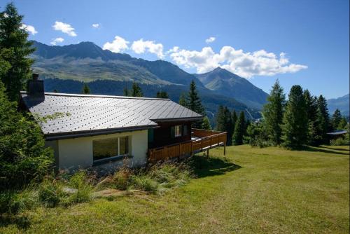 une maison dans un champ avec des montagnes en arrière-plan dans l'établissement Oreas (724 Du), à Valbella