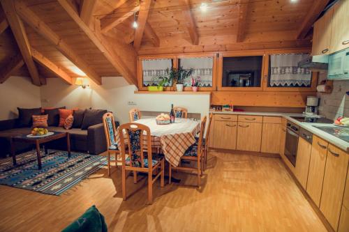 uma cozinha e sala de estar com uma mesa e um sofá em Appartements Tlusel em Ortisei