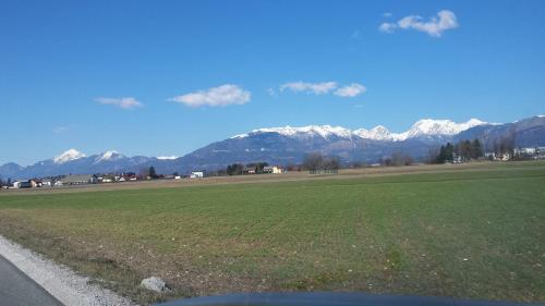 un campo con montagne innevate sullo sfondo di Apartma Rodica a Domžale