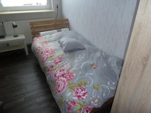 - un lit avec une couverture florale et des oreillers dans l'établissement im gelben Haus, à Trusen