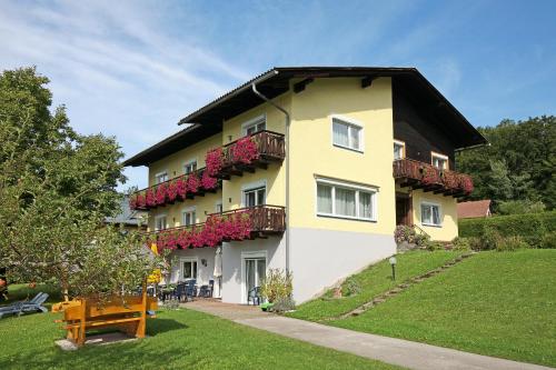 - un grand bâtiment avec des fleurs sur les balcons dans l'établissement Pension Sonnengrund, à Reifnitz