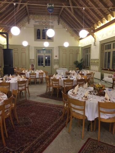 uma grande sala de jantar com mesas e cadeiras em Hôtel de la Truite em Champ-du-Moulin