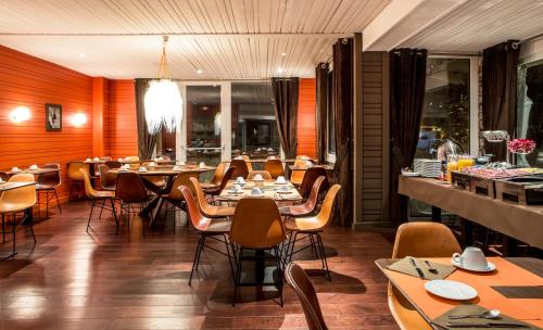 een restaurant met houten muren en tafels en stoelen bij Hotel Ormelune in Val dʼIsère