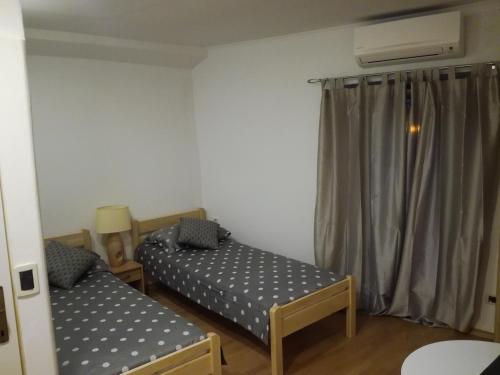 een kleine kamer met 2 bedden en een raam bij Guest House Kvartin in Umag