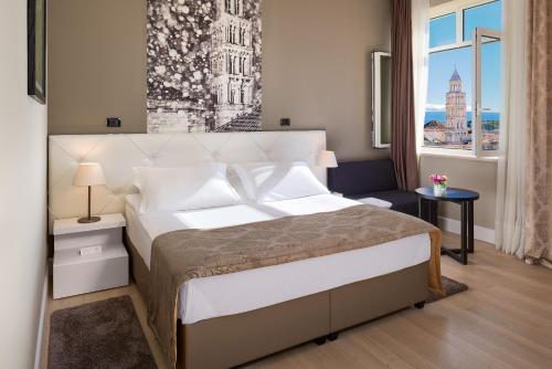 Un dormitorio con una cama grande y una ventana en Cornaro Hotel, en Split