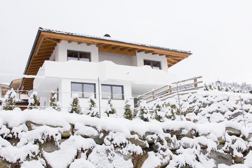 una casa ricoperta di neve su una collina di Apart Bergwärts a Fügen