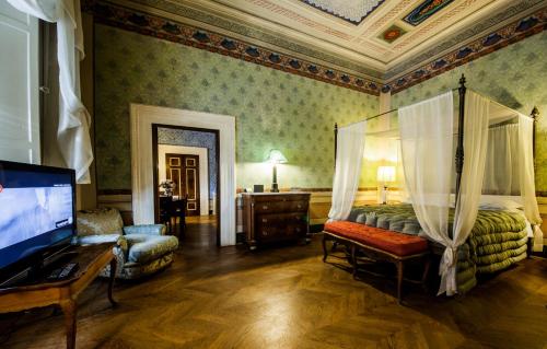 een slaapkamer met een bed en een flatscreen-tv bij Palazzo Rocchi - Residenza D'Epoca in Lucca