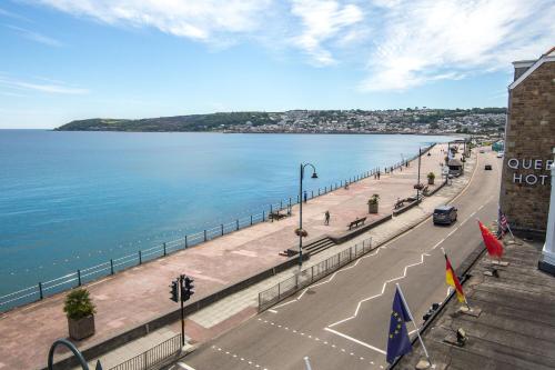 uma rua ao lado de um corpo de água em The Queens Hotel em Penzance