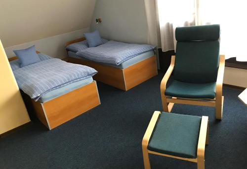 een kamer met 2 bedden en een stoel en een stoel bij Penzion Z&Z in Tábor