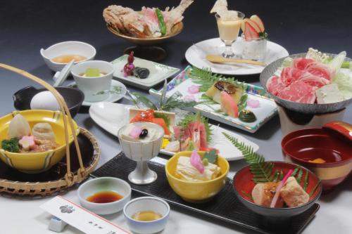 una mesa con muchos platos de comida. en Hotel Seikoen, en Nikko