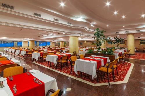 um restaurante com mesas e cadeiras e toalhas de mesa vermelhas em Hotel Gołębiewski Mikołajki em Mikołajki