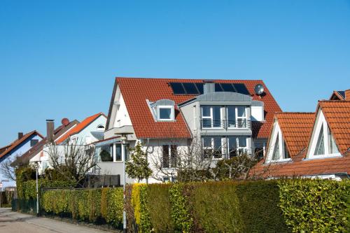 a row of houses with red roofs and a fence at Apartment D&D Spessart in Ettlingen