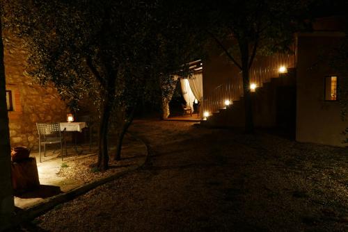 un patio oscuro con una mesa y árboles por la noche en Agriturismo La Pieve, en Colle Val D'Elsa