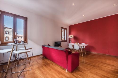 uma sala de estar com uma parede vermelha e um sofá vermelho em Ca' d'Oro suite em Veneza