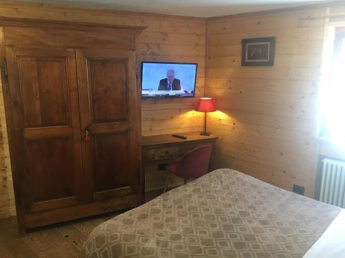 1 dormitorio con 1 cama y TV en la pared en B&B Gressoney, en Gressoney-la-Trinité