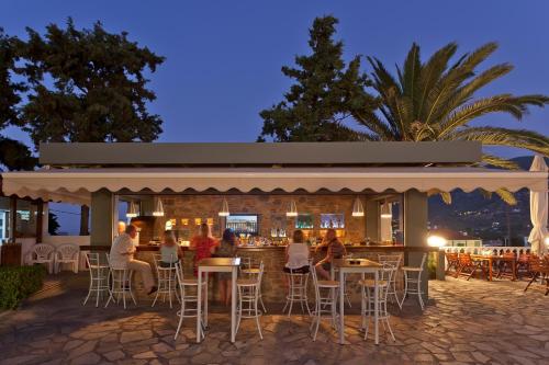 een groep mensen die 's nachts aan een bar zitten bij Dionyssos in Skopelos Town