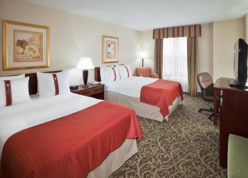 Holiday Inn Chantilly-Dulles Expo Airport, an IHG Hotel في شانتيلي: غرفه فندقيه سريرين وتلفزيون