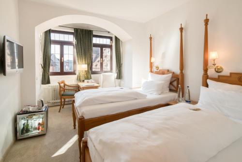 a hotel room with two beds and a window at Hotel Deutscher Kaiser in Nürnberg