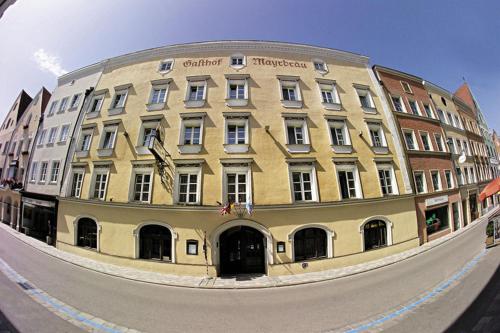 un grand bâtiment jaune en face d'une rue dans l'établissement Ambiance Hotel - Braunau - Simbach, à Braunau am Inn