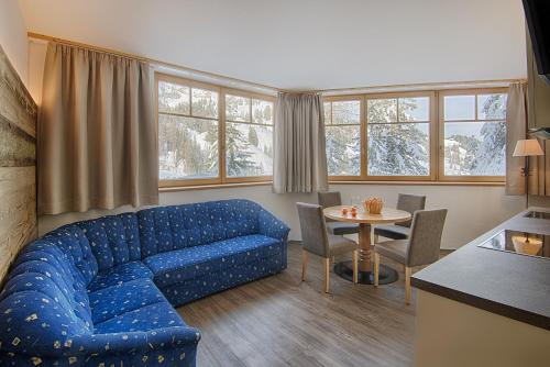 sala de estar con sofá azul y mesa en Hotel Garni Elisir, en Arabba