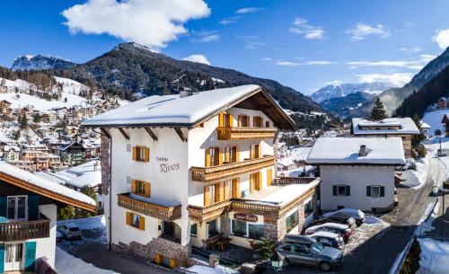 eine Luftansicht eines Hotels mit schneebedeckten Bergen in der Unterkunft Garni Rives in St. Ulrich in Gröden