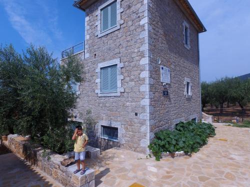 a man standing in front of a brick building at Kastro-Kardamili in Kardamili