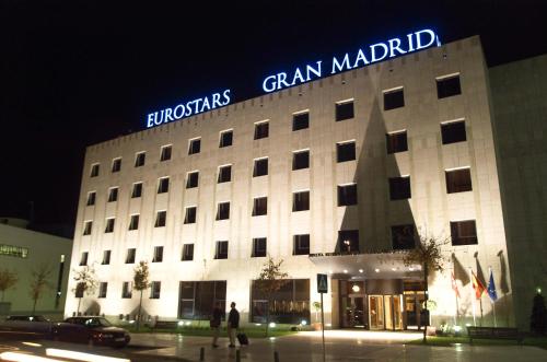 um edifício com um sinal em cima dele à noite em Eurostars Gran Madrid em Alcobendas