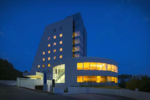 un gran edificio de oficinas con sus luces encendidas en Takamiya Hotel Rurikura Resort, en Zao Onsen