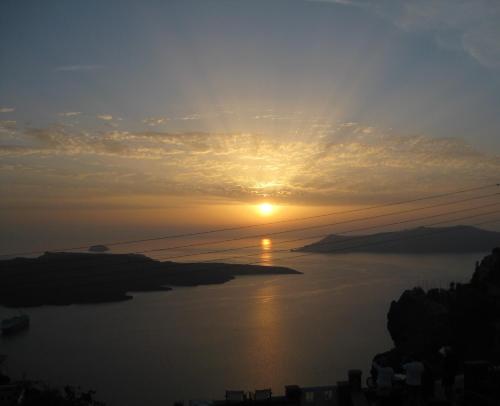 un tramonto su un corpo d'acqua di Le Petit Greek a Firà