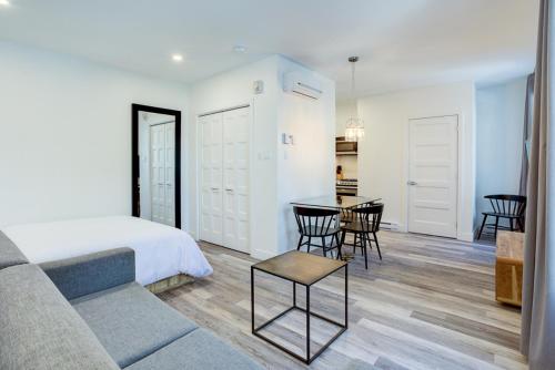 Schlafzimmer mit einem Bett, einem Tisch und Stühlen in der Unterkunft L'Adresse sur Grande-Allée Lofts in Québec