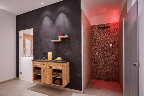 a bathroom with a shower with a wooden vanity and a wall at Hotel Garni Savoy in Castelrotto