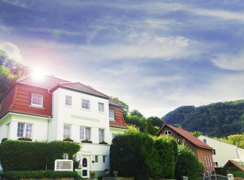 uma casa branca com um telhado vermelho em Hotel Garni Haus Sonneneck em Thale