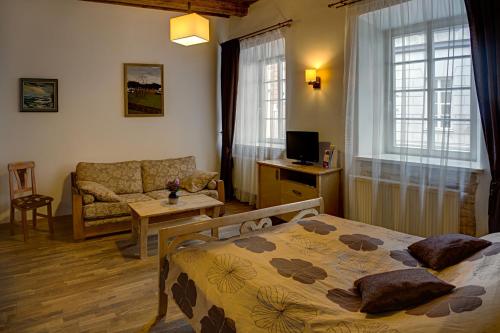 een slaapkamer met een bed en een woonkamer bij Bernardinu B&B House in Vilnius