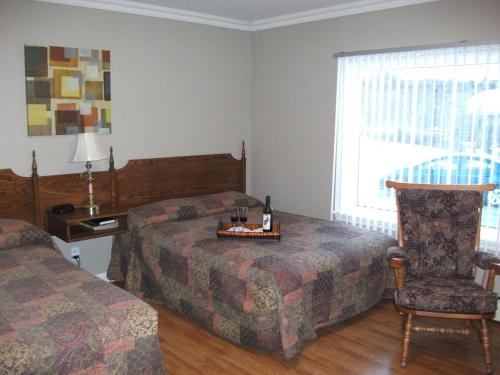 una camera d'albergo con due letti e una sedia di Silverwood Inn Hotel Bay Roberts a Bay Roberts