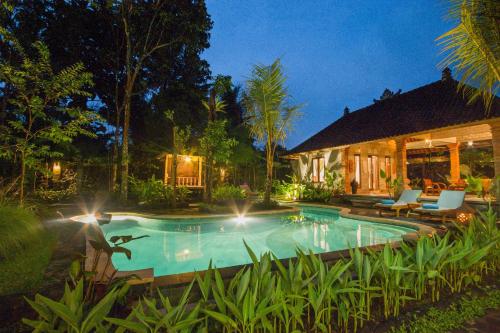 ein Schwimmbad vor einem Haus in der Nacht in der Unterkunft Jero Sebali Villa in Ubud