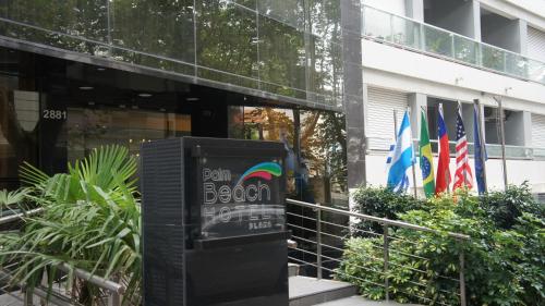 a sign in front of a building with flags at Palm Beach Plaza Hotel in Montevideo