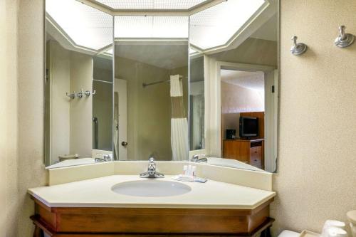 a bathroom with a sink and a large mirror at Baymont by Wyndham Amarillo East in Amarillo