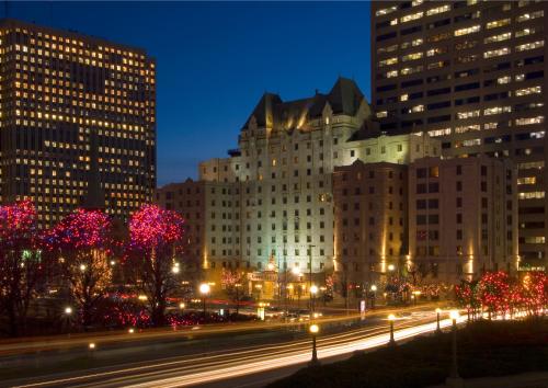 eine nachts beleuchtete Stadt mit Gebäuden und Straßenbeleuchtung in der Unterkunft Lord Elgin Hotel in Ottawa