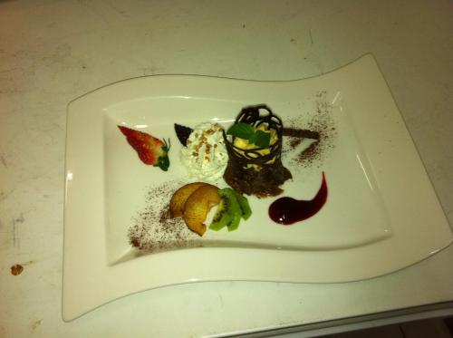 a white plate with food on a table at Oder-Hotel in Schwedt