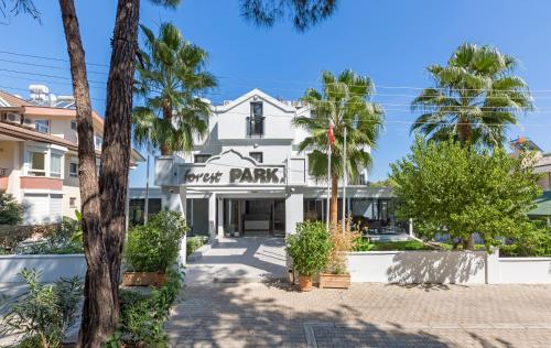 un bâtiment blanc avec un panneau indiquant le parc des grovers dans l'établissement Forest Park Hotel, à Kemer