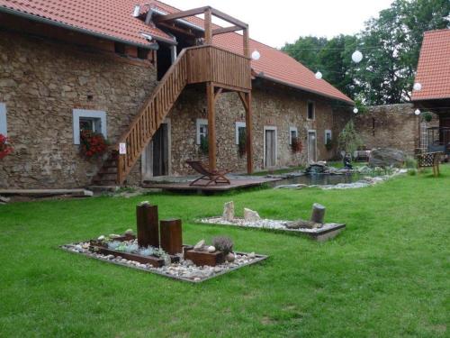 a stone house with a wooden stairway in a yard at Statek Kloubek in Chabičovice