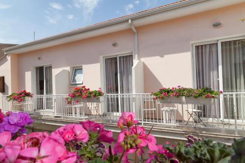 une maison blanche avec des fleurs sur les balcons dans l'établissement Hotel Opera, à Larnaka